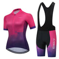 Kit de ciclismo feminino com uma camisa gradiente rosa e roxa e shorts com babador combinando.