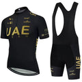 Uniforme de ciclismo com camisa e shorts pretos com a inscrição ’UAE’ em letras douradas.