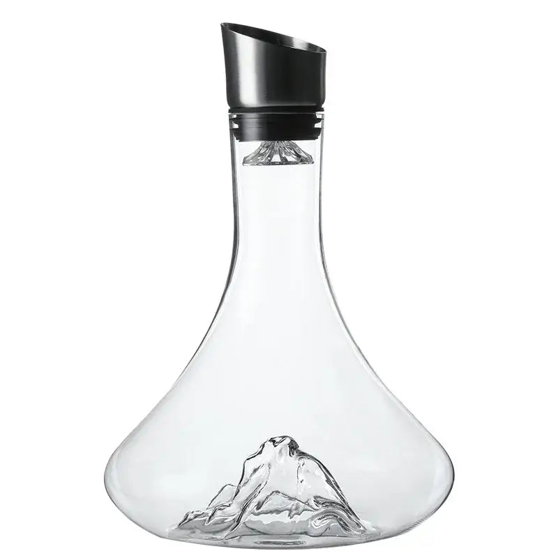 Decanter de vidro com um entalhe em forma de montanha em sua base e uma rolha preta.