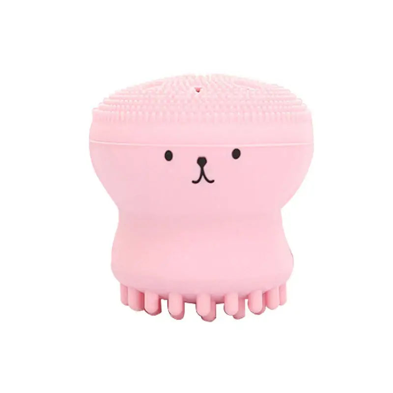 Escova de limpeza facial de silicone em forma de polvo rosa com um rosto de desenho animado.