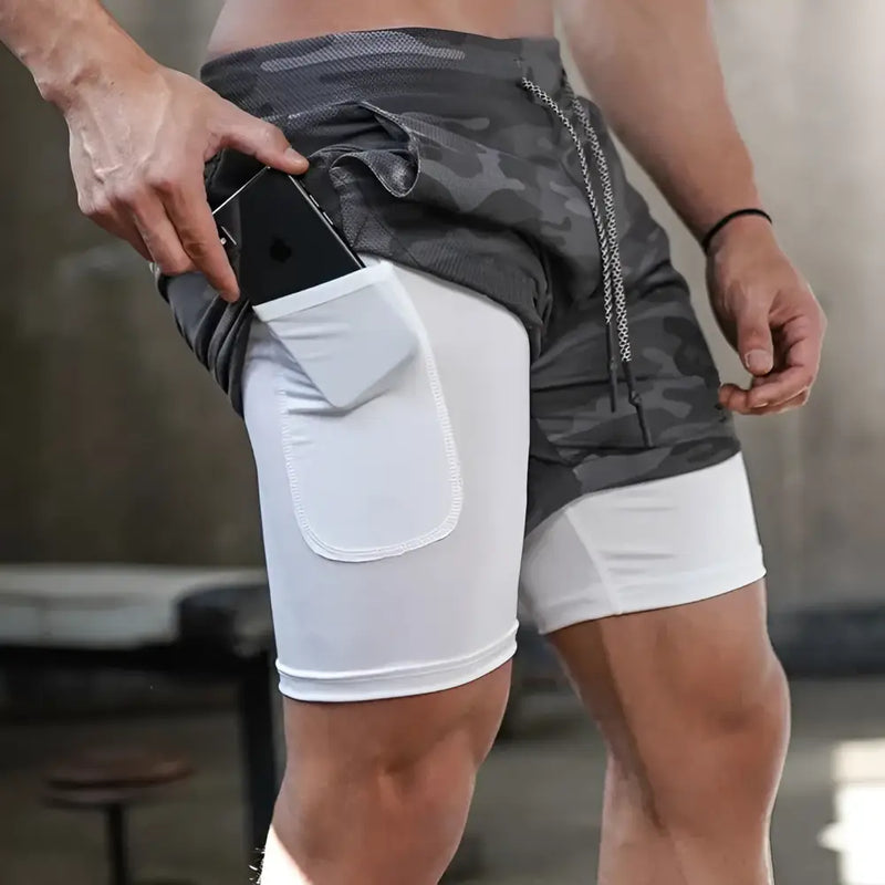 Shorts esportivos de duas camadas com camada de compressão branca por baixo e camada externa cinza com padrão de camuflagem.